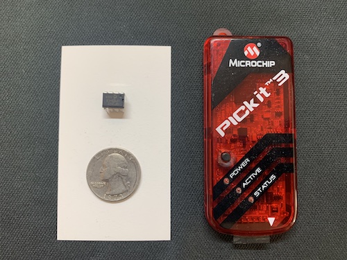 PIC12F1822 Microcontroller next to a PICkit programmer and a quarter for scale